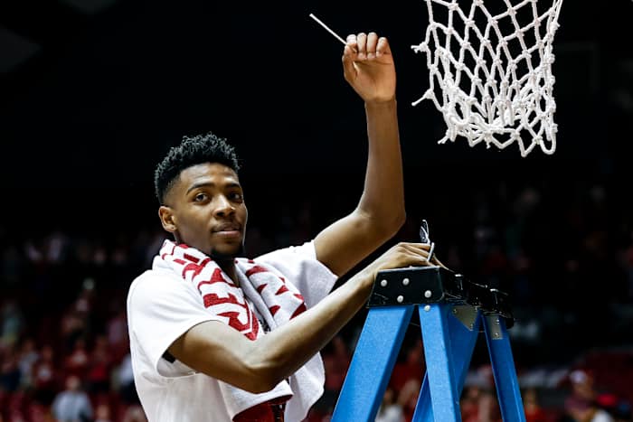 Alabama Crimson Tide forward Brandon Miller (24) celebrates regular season SEC champions by cutting down the net after an NCAA basketball game against the Auburn Tigers at Coleman Coliseum.